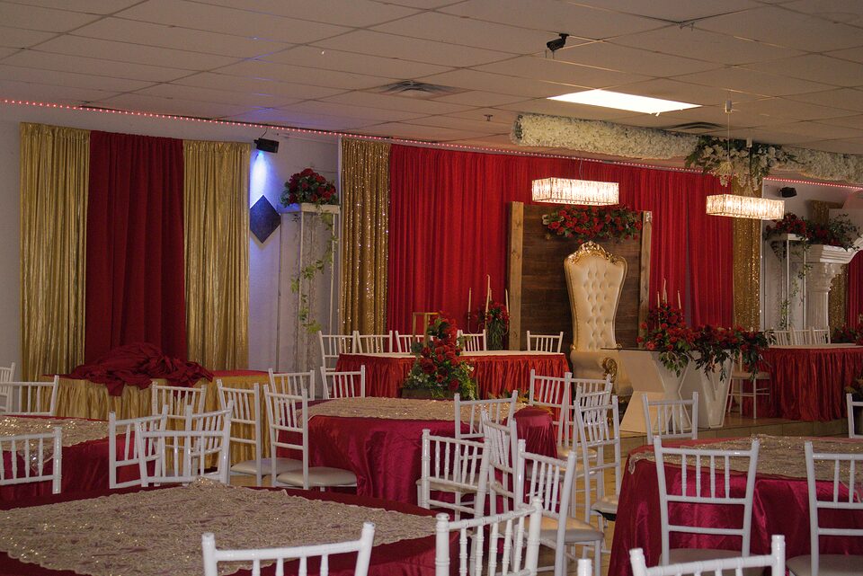 Salon con cortinas doradas y mesas montadas para banquete