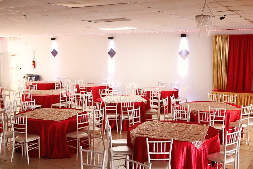 Salon montado con mesas redondas y sillas Chiavari blancas