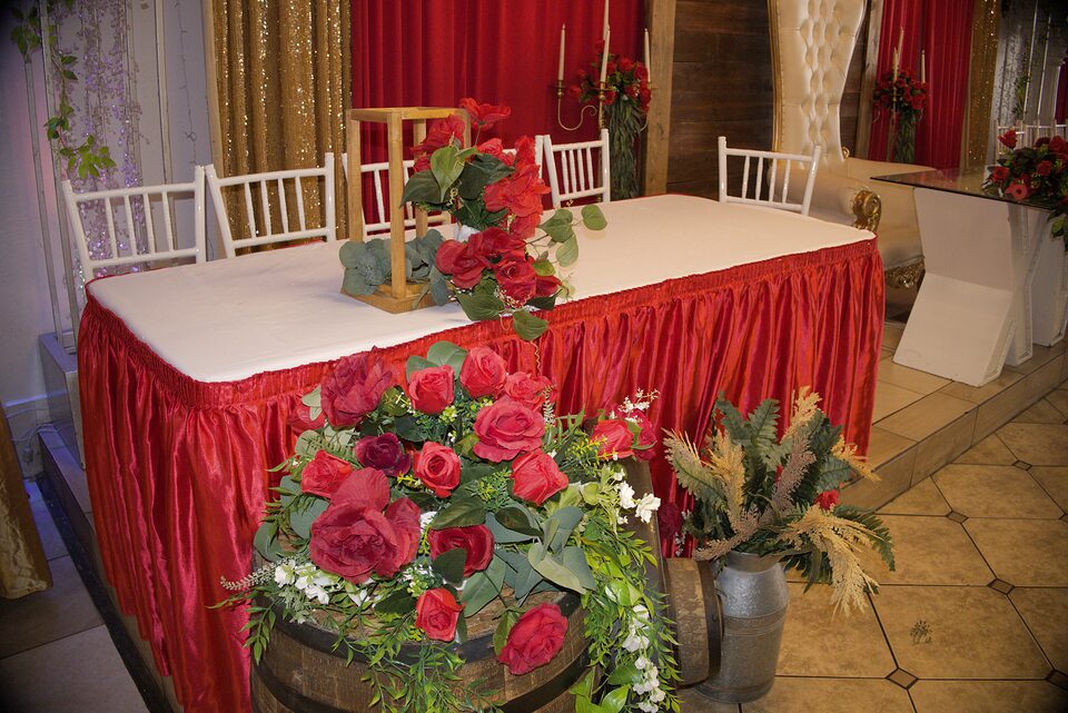 Mesa de novios con rosas rojas y decoracion rustica de barril